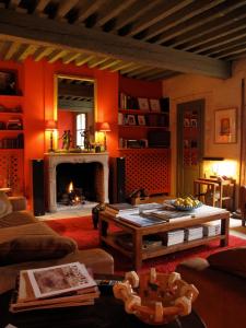 a living room with orange walls and a fireplace at Hotel Les Templiers in Aigues-Mortes