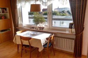 een eetkamer met een tafel en een groot raam bij Westerland mit Sonnenbalkon in Westerland