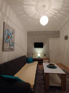 a living room with a couch and a table at Apartments Tulipan - with free private parking in Mostar