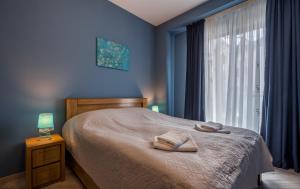 a bedroom with a bed with blue walls and a window at New Gudauri, Loft 1, #114, Cosy Apartment -Gondola lift in Gudauri