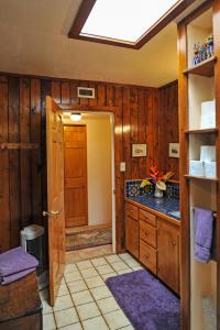 a bathroom with wooden walls and a ceiling with a skylight at Heart and Wings Retreat Center in Silver City