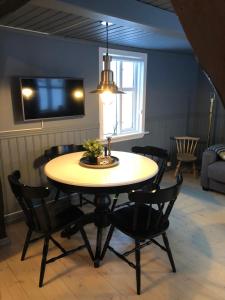 a dining room with a table and chairs and a television at The Little House in Bolungarvík