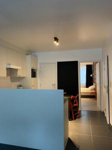 a kitchen with white cabinets and a view of the ocean at Elma’s Place in Ghent