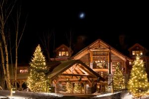 a log cabin decorated with christmas trees and lights at The Whiteface Lodge in Lake Placid