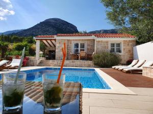 a drink sitting on a table next to a swimming pool at Apartments Lolita in Bol