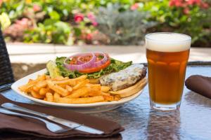 Un plato de comida con un sándwich, patatas fritas y un vaso de cerveza. en Holiday Inn Resort Daytona Beach Oceanfront by IHG, en Daytona Beach