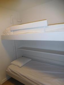 two bunk beds in a small room with a bed at plaza in De Panne