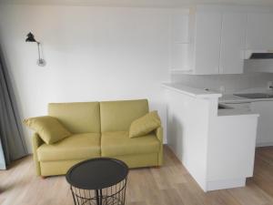 - un salon avec un canapé jaune et une table dans l'établissement plaza, à La Panne