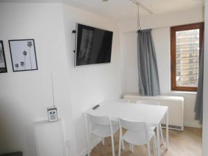 a white dining room with a white table and chairs at plaza in De Panne