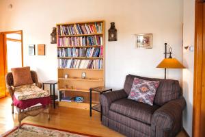 a living room with a couch and a book shelf with books at Heart and Wings Retreat Center in Silver City