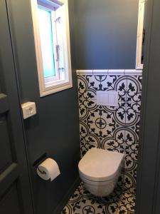 a small bathroom with a toilet and a window at The Little House in Bolungarvík