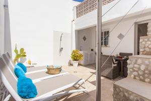 eine Terrasse mit einem weißen Stuhl und einem Tisch in der Unterkunft Beach House Sa Torre in Colonia Sant Jordi