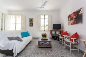 un soggiorno con divano bianco e TV di Beach House Sa Torre a Colonia Sant Jordi
