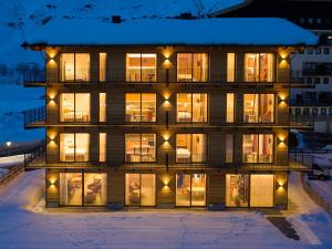 une maison dans la neige la nuit avec des lumières dans l'établissement Red Fox Lodge, à Breuil-Cervinia