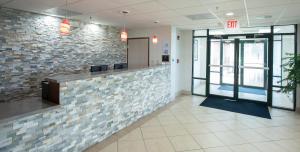 un vestíbulo de oficina con una pared de piedra en Americas Best Value West Point, en West Point