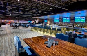 a restaurant with a wooden table and a bar at Hotel Apache in Las Vegas