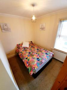 a bedroom with a bed with a floral comforter at Chelmsford Centre House in Chelmsford