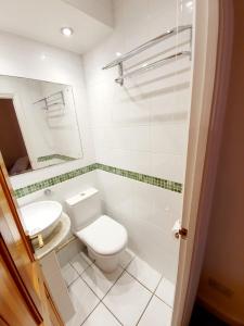 a white bathroom with a toilet and a sink at Chelmsford Centre House in Chelmsford