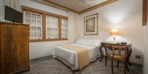 a bedroom with a bed and a table with a lamp at Pousada do Douro in Ouro Preto