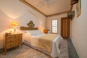 a bedroom with a bed and a lamp on a dresser at Pousada do Douro in Ouro Preto