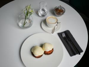 a white table with a plate of food and a cup of coffee at Vila Komoda in Palanga