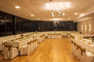 a banquet hall with white tables and chairs in it at Hotel Italia in Cuenca