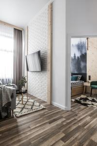 a living room with wooden flooring and a white brick wall at Black River Apartment in Czarny Dunajec