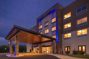 um edifício de escritórios com uma fachada iluminada à noite em Holiday Inn Express & Suites Farmville, an IHG Hotel em Farmville