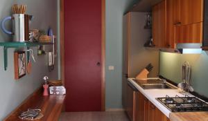 a kitchen with a red door next to a counter at Seaside Villa in Bagheria