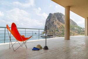 a red chair on a balcony with a view of the ocean at Seaside Villa in Bagheria