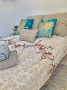 a bed with several pillows and a blanket on it at La Ciotat La plus belle baie du monde - Terrasse Appartement 4 couchages in La Ciotat