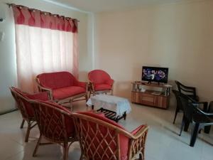a living room with chairs and a table and a tv at ExoTika Villa in Trou aux Biches