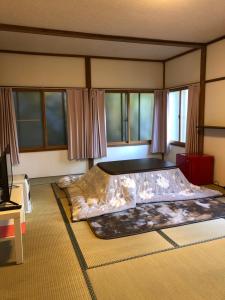 a large bed in a room with windows at Oyado Zen in Kusatsu