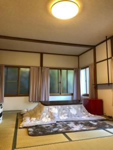 Cama grande en habitación con ventanas en Oyado Zen, en Kusatsu