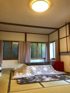 a large bed in a room with windows at Oyado Zen in Kusatsu