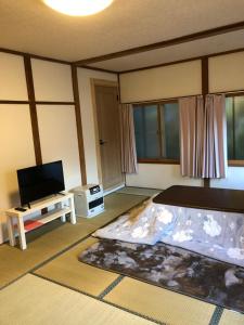 a living room with a bed and a television at Oyado Zen in Kusatsu +37 photos