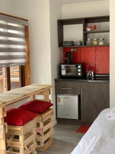 a room with a kitchen with a table and a counter at Rumbo Suites in Punta Arenas