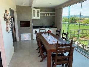 cocina y comedor con mesa y sillas en Pinheira Beach Residence, en Palhoça