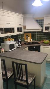a kitchen with a counter with two chairs and a microwave at Casa Vacanze Villa Paradiso in Maratea