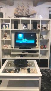 a white entertainment center with a tv and a table at Casa Vacanze Villa Paradiso in Maratea