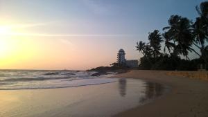 a view of a beach with a lighthouse in the distance at Sunset Beach Cabana in Ambalangoda