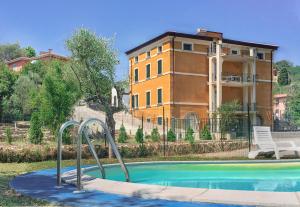 a swimming pool in front of a house with a building at HOTIDAY Apartment Collection - Lerici Terrediliguria in Lerici