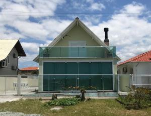 una casa con un gran garaje verde en Pinheira Beach Residence, en Palhoça