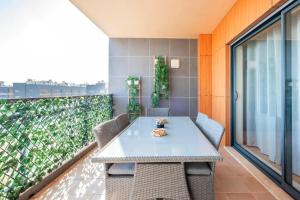een tafel en stoelen op het balkon van een gebouw bij ★ OCEANFRONT: Luxury Breathtaking Views and Pool ★ in Olhão