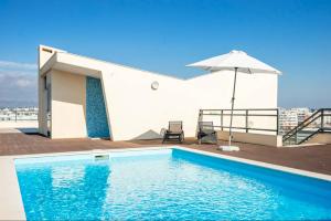 a pool on the roof of a building with an umbrella at ★ OCEANFRONT: Luxury Breathtaking Views and Pool ★ in Olhão