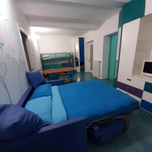 ein Wohnzimmer mit einem blauen Sofa und einem Tisch in der Unterkunft La Corte 20 Studio Apartments in Carugo