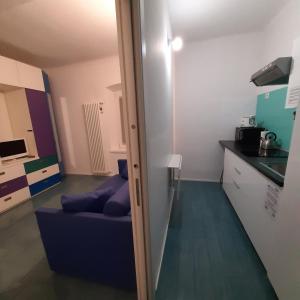 ein Wohnzimmer mit einem blauen Sofa in einem Zimmer in der Unterkunft La Corte 20 Studio Apartments in Carugo