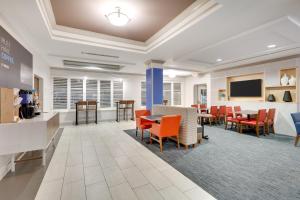 a waiting room at a hospital with orange chairs and tables at Holiday Inn Express Hotel & Suites Dublin, an IHG Hotel in Dublin