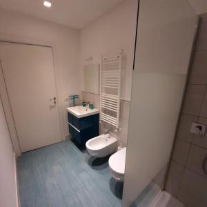 a bathroom with a white toilet and a sink at La Corte 20 Studio Apartments in Carugo