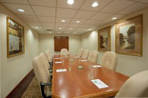 una sala conferenze con un lungo tavolo in legno e sedie bianche di Holiday Inn Portsmouth, an IHG Hotel a Portsmouth